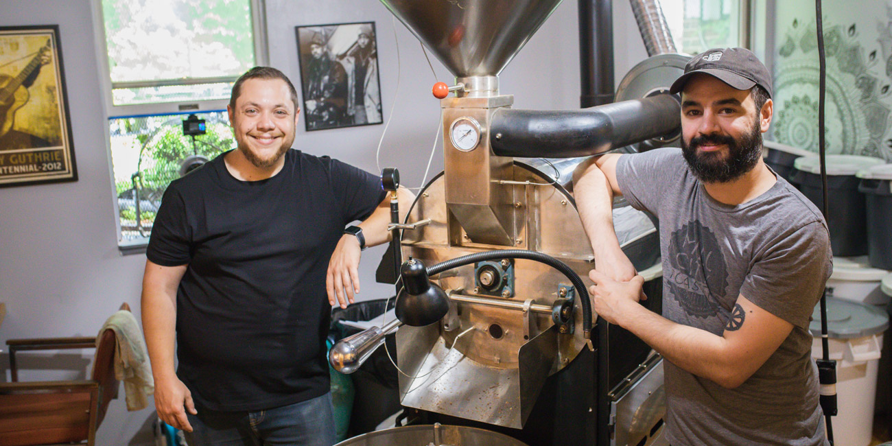 Two people standing with machinery