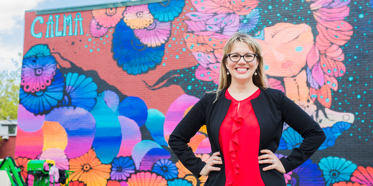 Missy Hartney standing in front of a mural