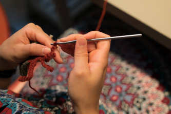 A close-up of a participant in Raise the Reef Tuesdays crocheting. 