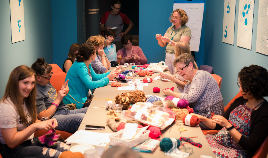 Artist Stacy Hortner standing among the other crocheters. 