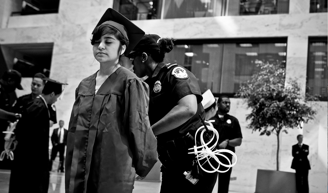 Photo of immigrant student in graduation cap and gown being handcuffed by police