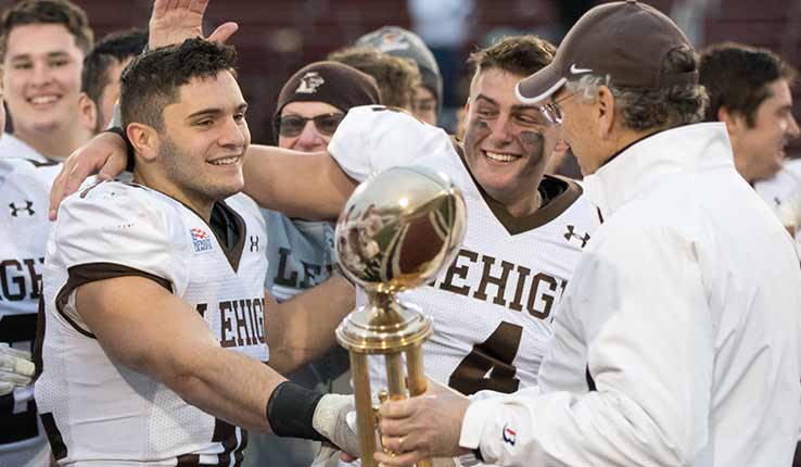 football players accepting trophy