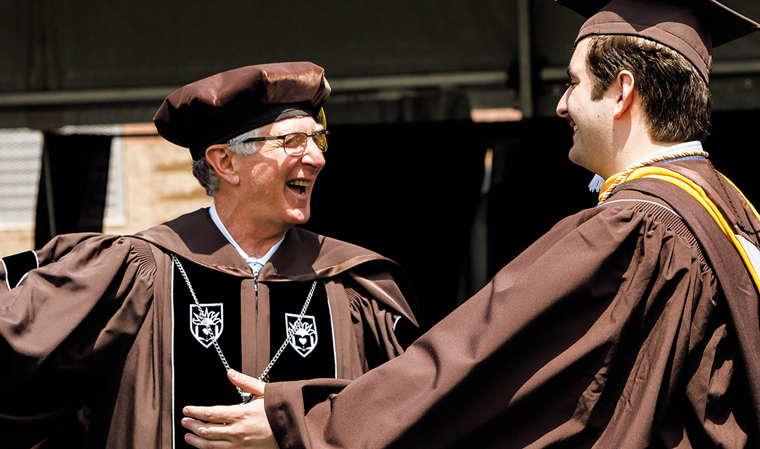 Simon embraces his son Evan at his graduation