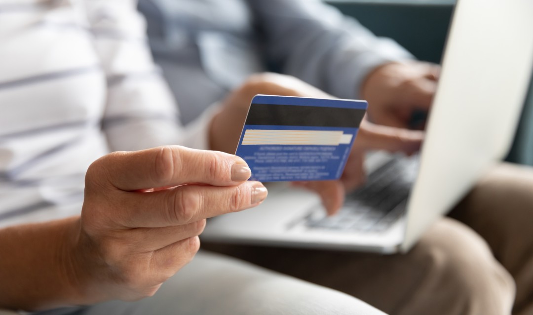 couple holding credit card and laptop