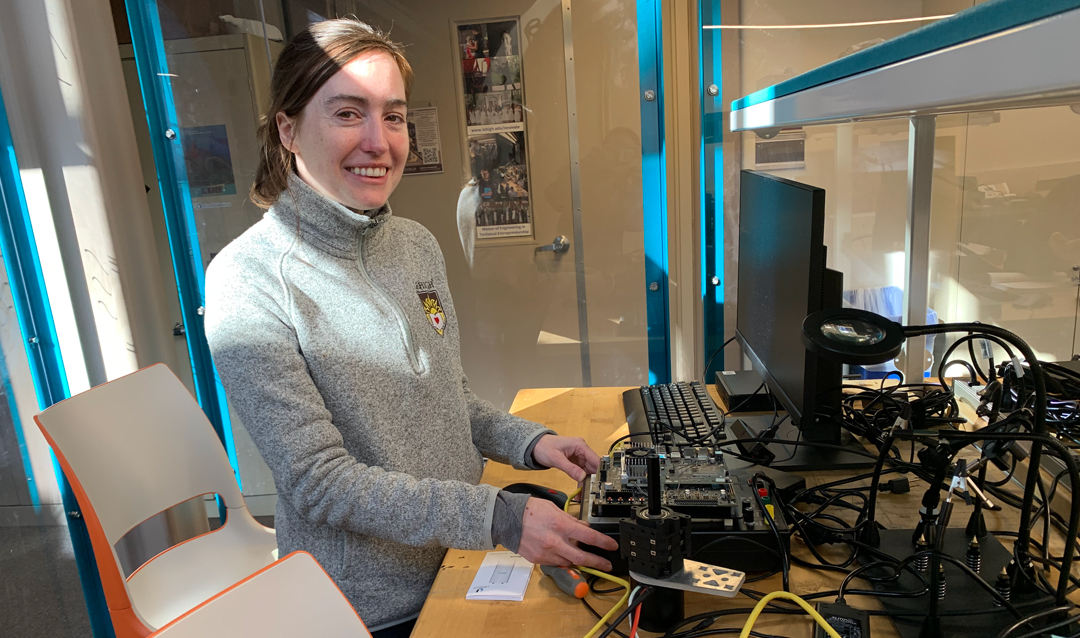 Kelly Zona shows a device in the Electronics Design Studio.