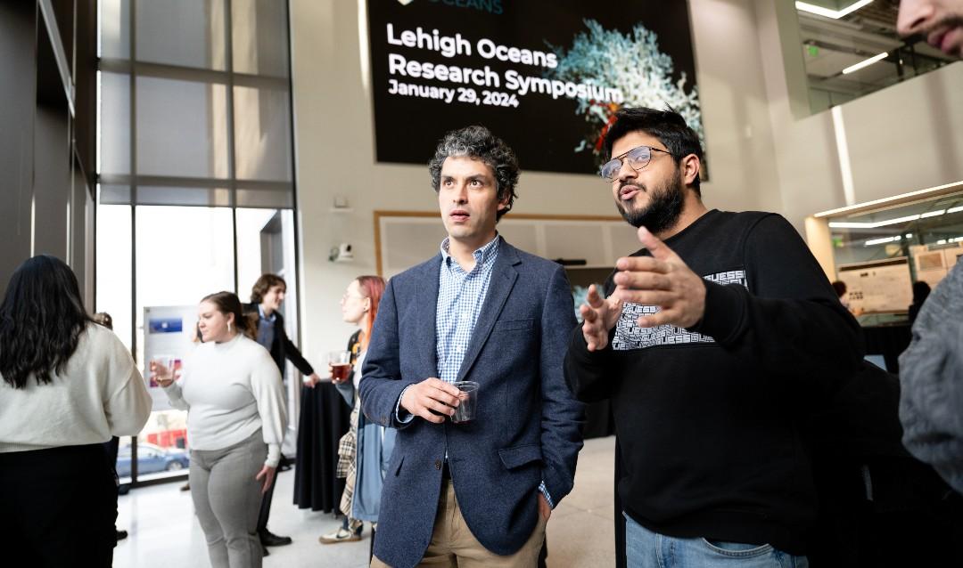 Santiago Herrera, assistant professor of biological sciences, reviews a poster