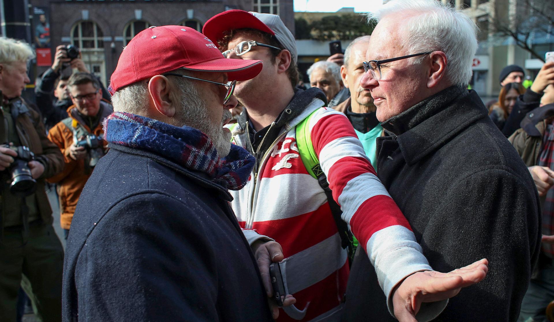 A man intervenes as an argument between two opposing sides escalates outside of the Trump International Hotel and Tower during its grand opening in Vancouver in 2017. 