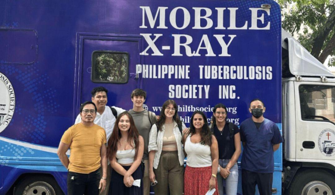 Team members of the TrackTB project pose for a photo with locals in front of the mobile X-ray truck in the Philippines.