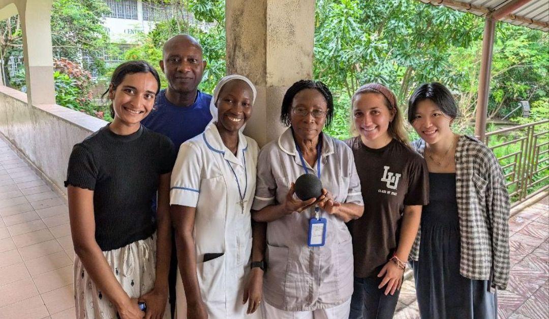 The Artificial Intelligence Strengthening Healthcare Access (AISHA) team passes the Alexa device to a health provider in Sierra Leone.