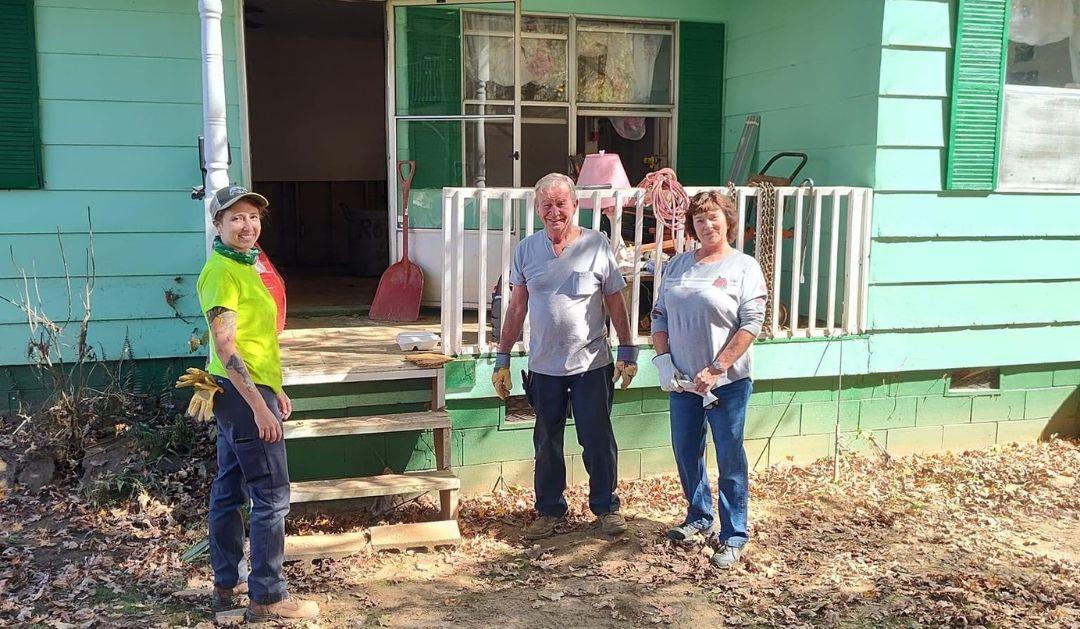 Katie Gregory and other volunteers gather in front of the home that Ashley Kreitz and her volunteer team restored in Barnardsville, North Carolina. 