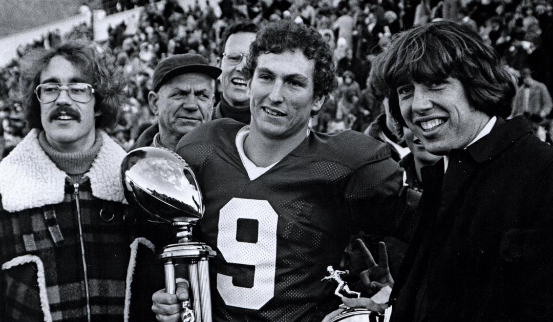 Joe Sterrett ’76, center, with the MVP trophy for The Rivalry game, which he won as quarterback in 1975.