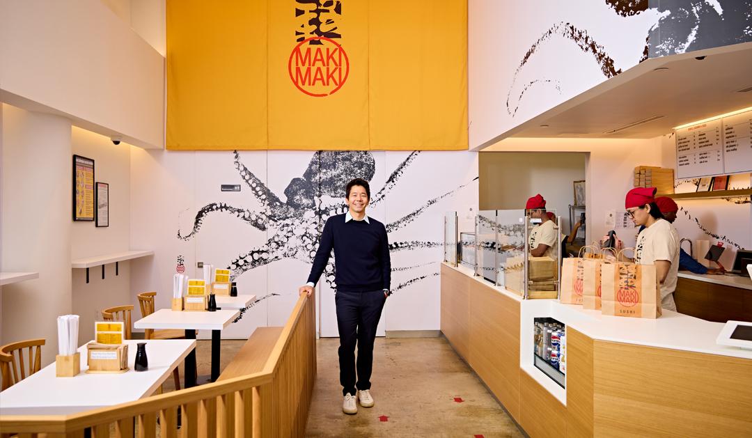 Kevin Takarada ’06G poses for a photo inside one one of his four MakiMaki Sushi locations in New York City. 