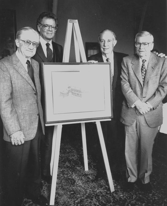 Donald B. Stabler, Murray H. Goodman, Philip Rauch and Harry T. Martindale standing in front of easel holding a blueprint.