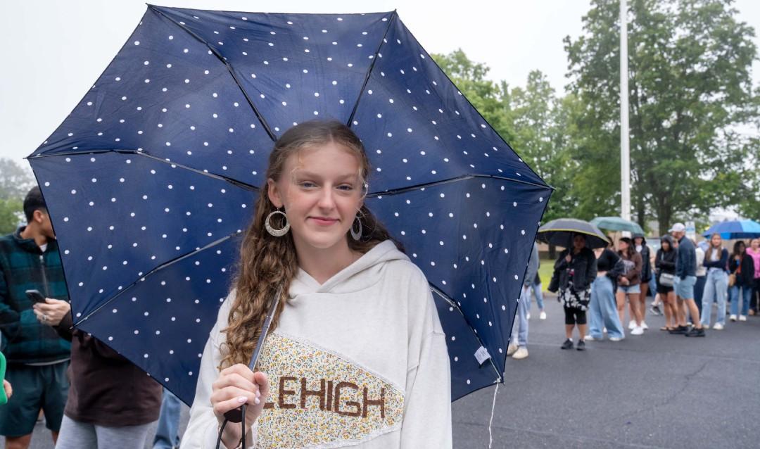 Student with umbrella waiting in check-in line