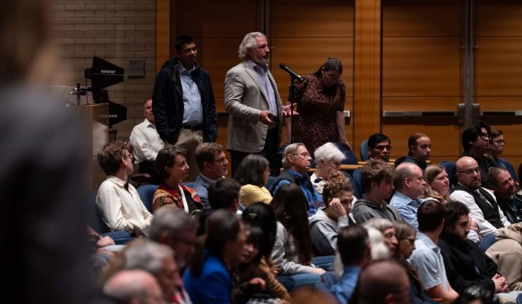 Audience member asking a question at a microphone