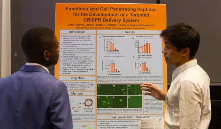 Two students talking in front of a poster