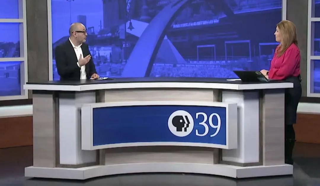 Two news anchors sitting at a desk