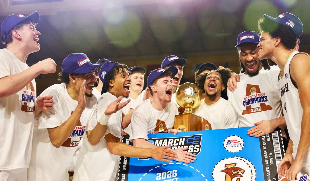 Jubilant basketball team celebrates championship with a golden trophy and banner.