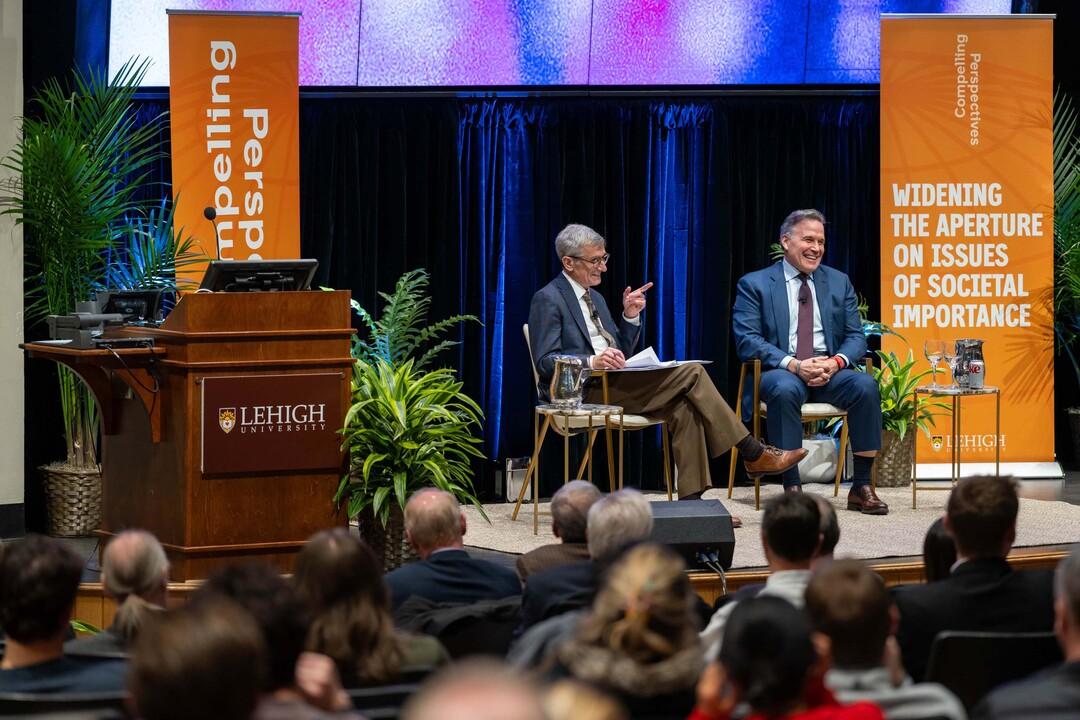 Senator Dave McCormick and Lehigh University President Joseph J. Helble speak on a university stage.