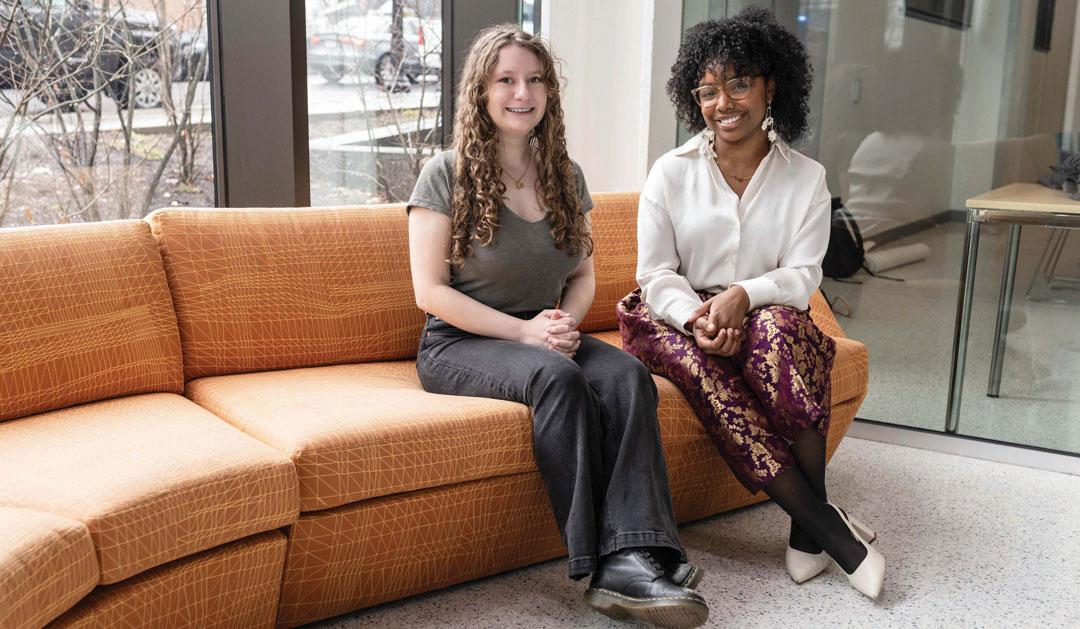 Julie Wright ’25 M’26 and Rhema Hooper ’26 sit on an orange couch in the Health, Science and Technology building..