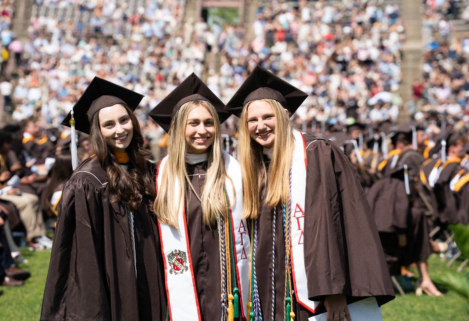 Three students smile during the ceremony. 