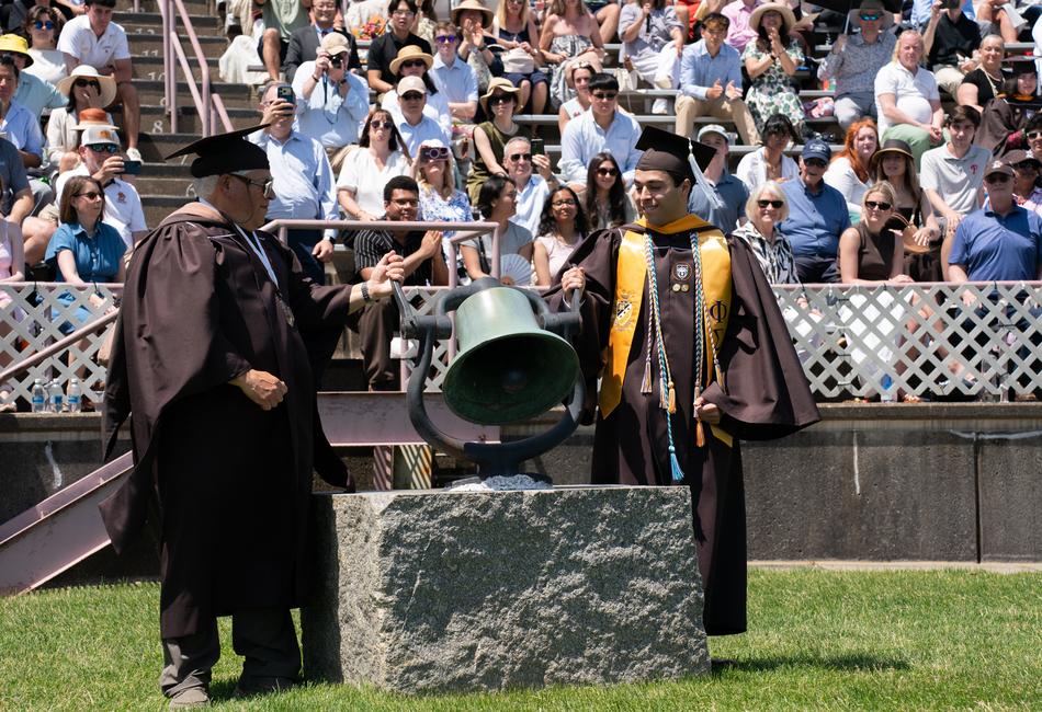 Alumni and student ring the bell.