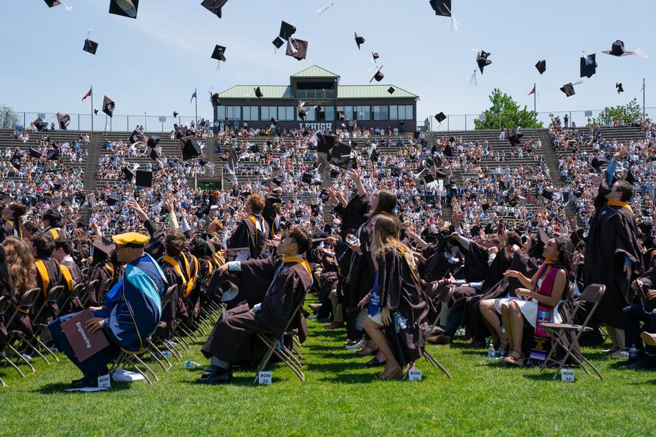 Graduates throw their caps in the air. 