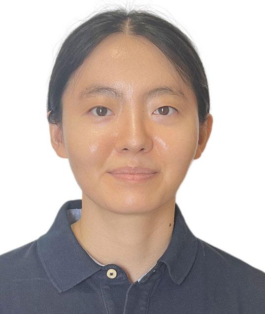 Photograph of a smiling woman in a navy blue collared shirt.