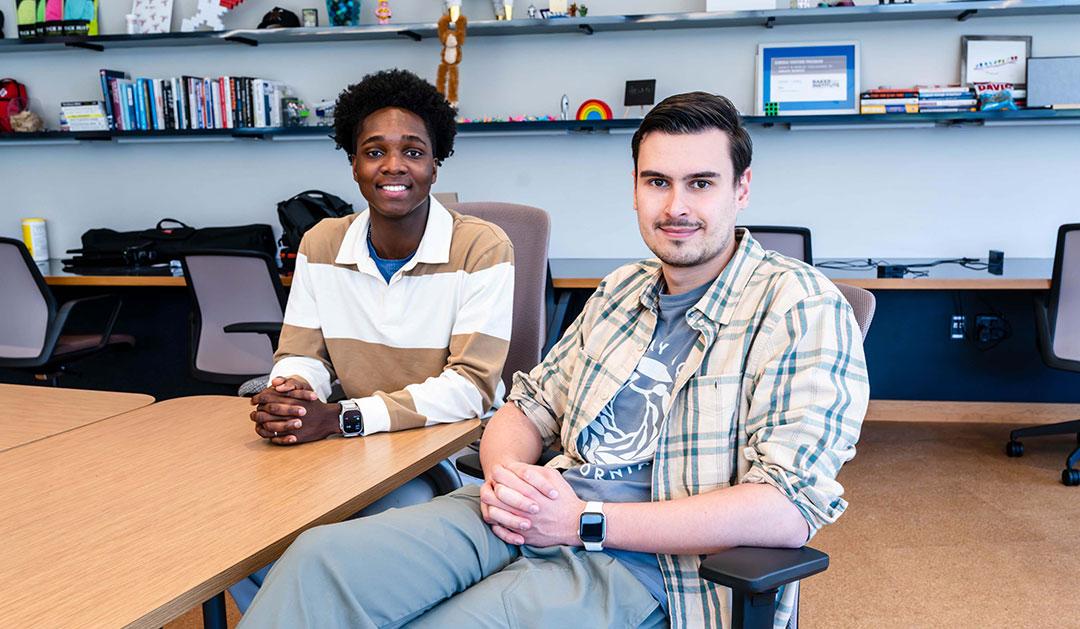 Photograph of Abdulrasaq (Dulra) Amolegbe ’26 and Roman Moskalenko ’26 sitting at a desk in a modern office.