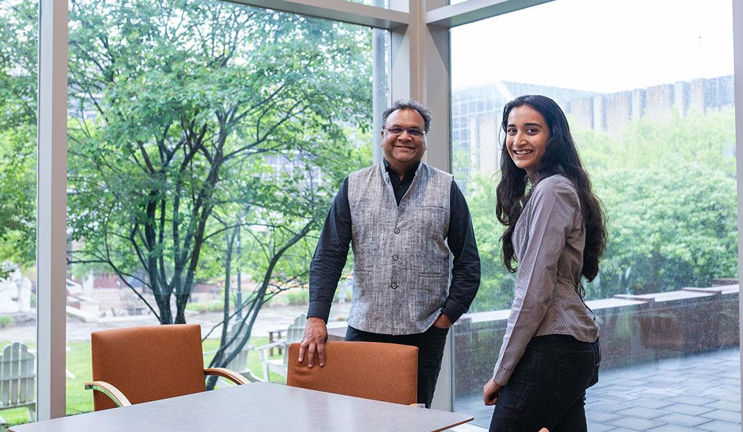 Photograph of Khanjan Mehta and Vrushti Patel '26 in a bright, modern office with large windows.