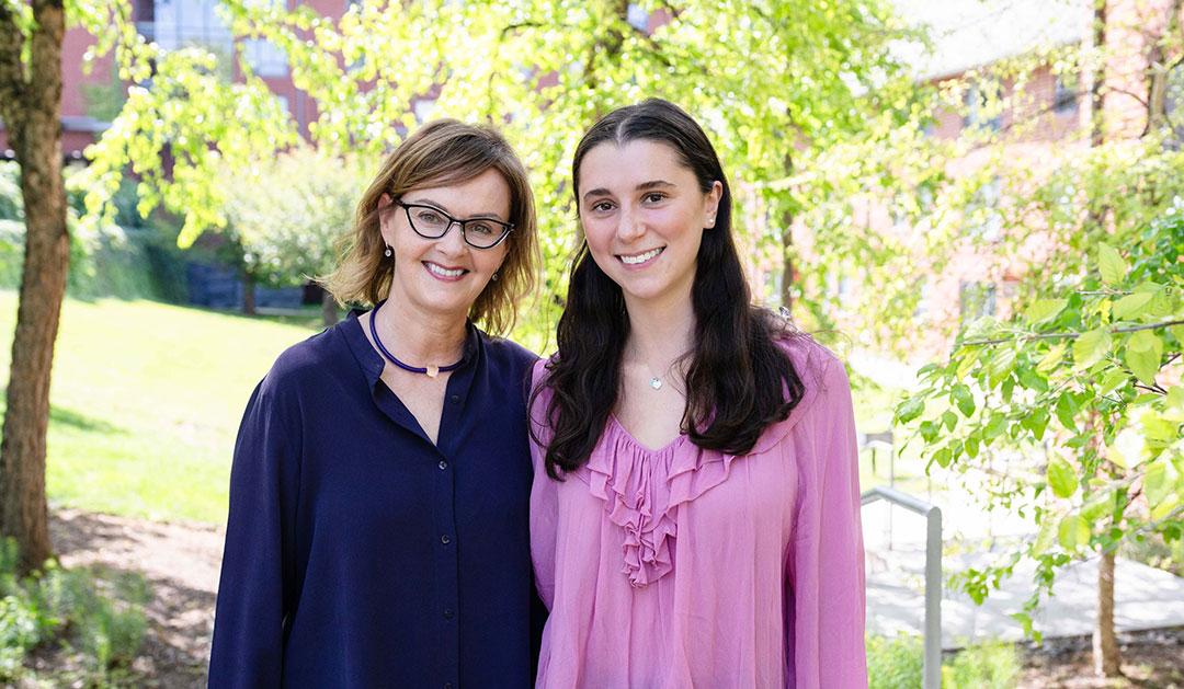Photograph of Joanna Mishtal and Natalie Werbel, one in a blue top and one in pink, smiling outdoors.