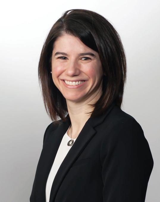 Photograph of a smiling woman with dark hair in a black blazer.