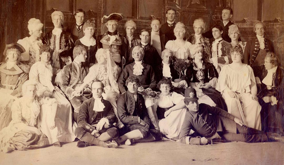 Sepia-toned group portrait of people in 18th-century period costumes.
