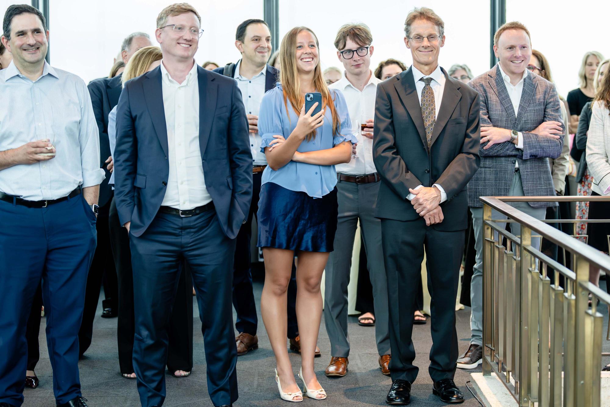 Photograph of a smiling group of business professionals at an event.