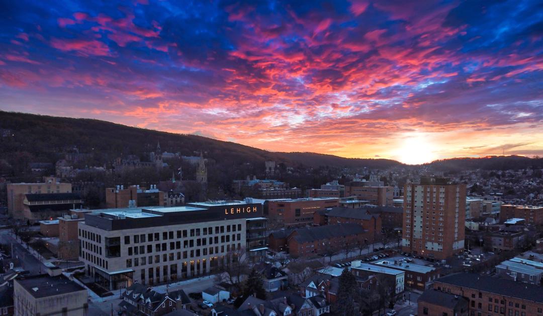Photograph of a vibrant pink and blue sunset over Lehigh University campus.