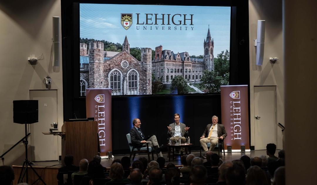 Three men on a stage leading a panel discussion at Lehigh University.