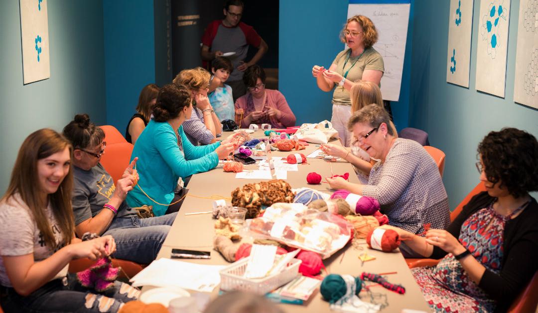 Artist Stacy Hortner standing among the other crocheters. 