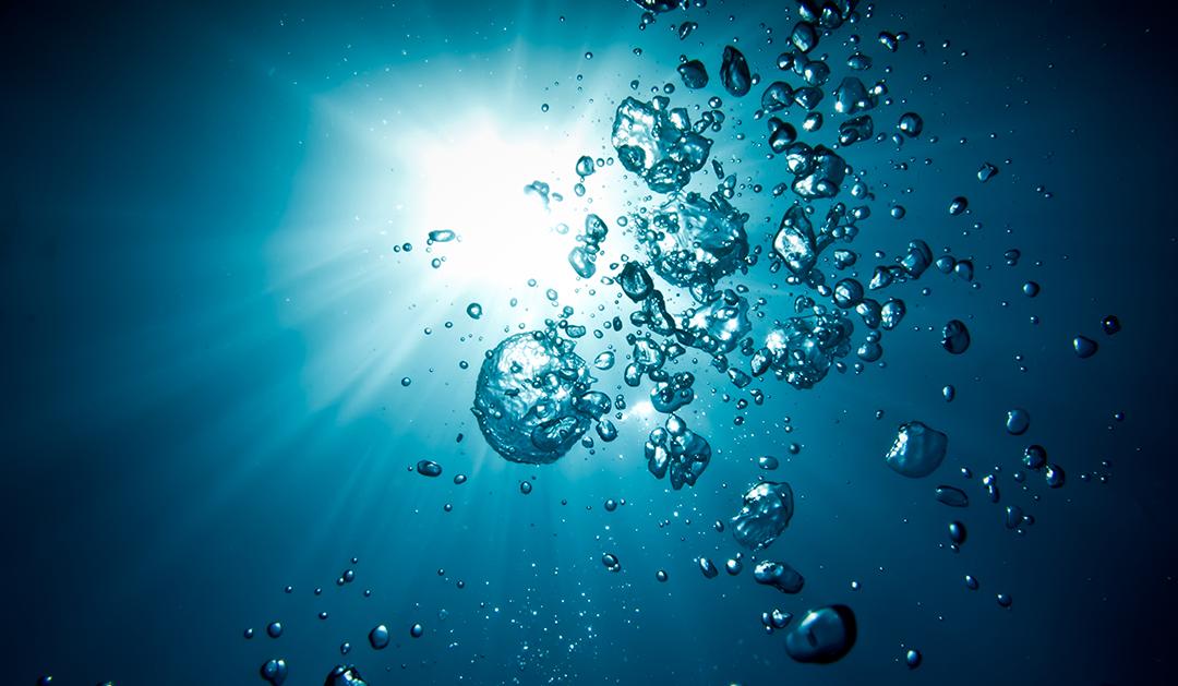 image of bubbles in water with sunlight shining down
