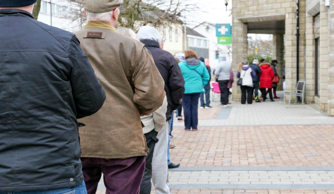 people standing in line to get into a pharmacy