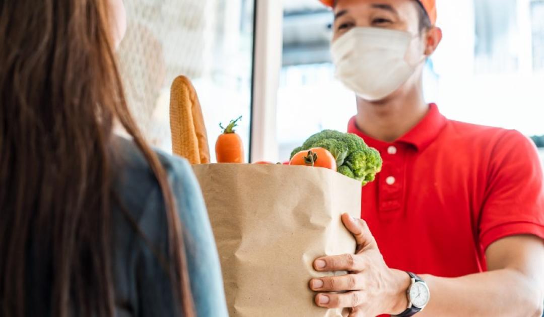 man in mask delivers groceries