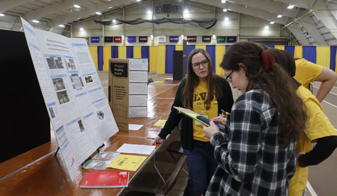 Student presenting research to judges at a research fair.