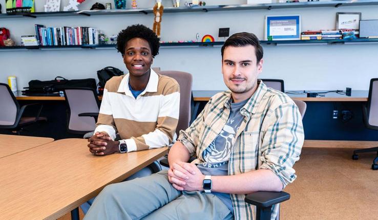 Photograph of Abdulrasaq (Dulra) Amolegbe ’26 and Roman Moskalenko ’26 sitting at a desk in a modern office.