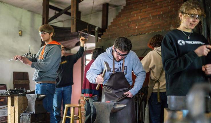 Three students gather in lab for blacksmithing club