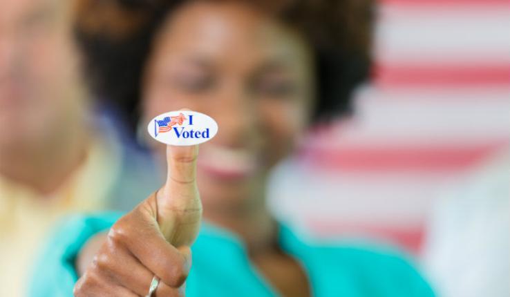 Person holding an "I voted" sticker