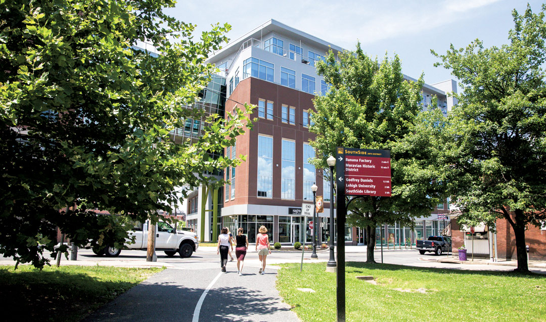 Three people walking on a path towards a building