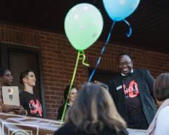 Henry Odi standing with balloons in the foreground